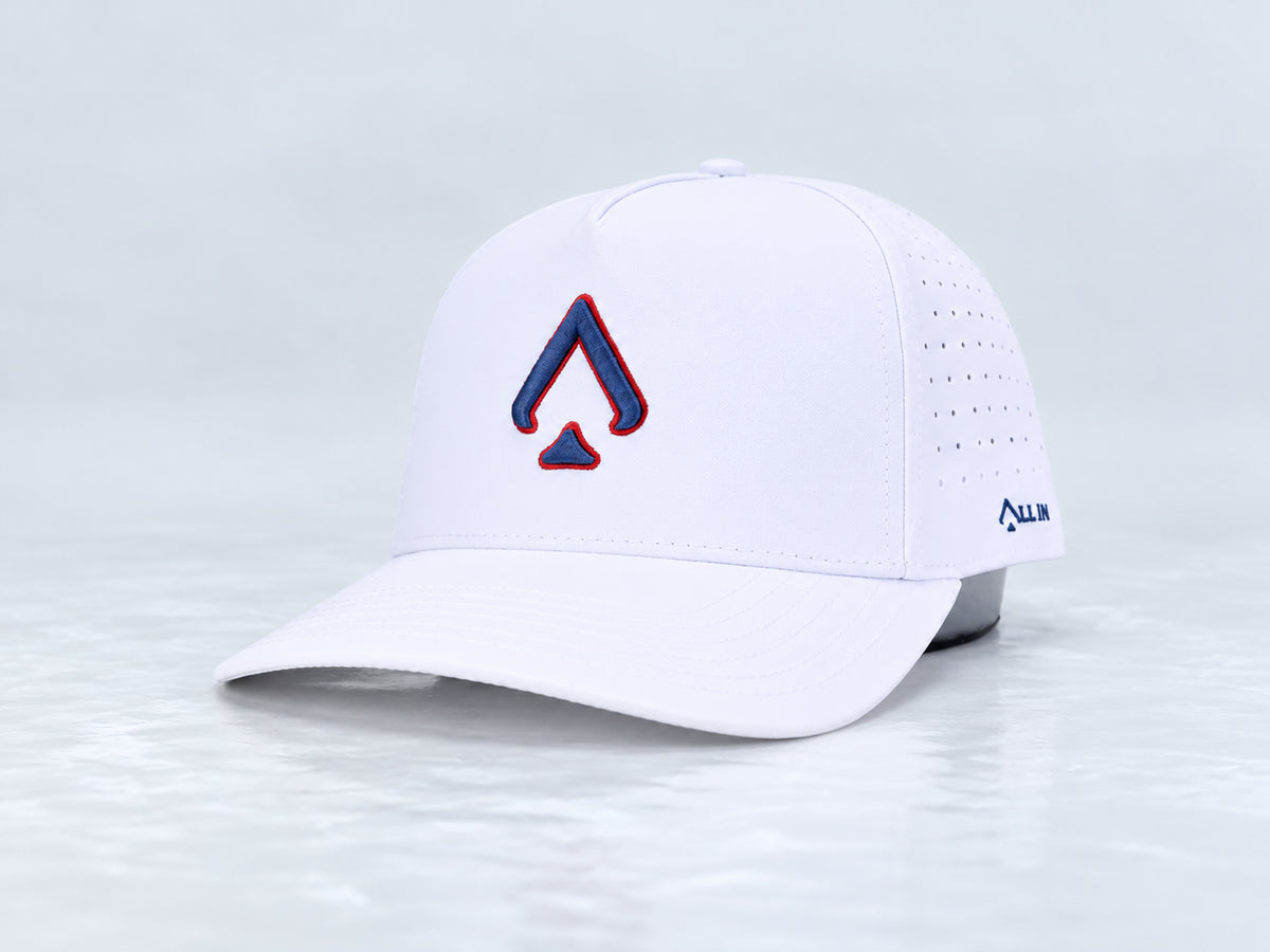 All In Lid American Dream white cap with navy blue outlined in red spade embroidery, front three-quarter view against a pale gray studio background.