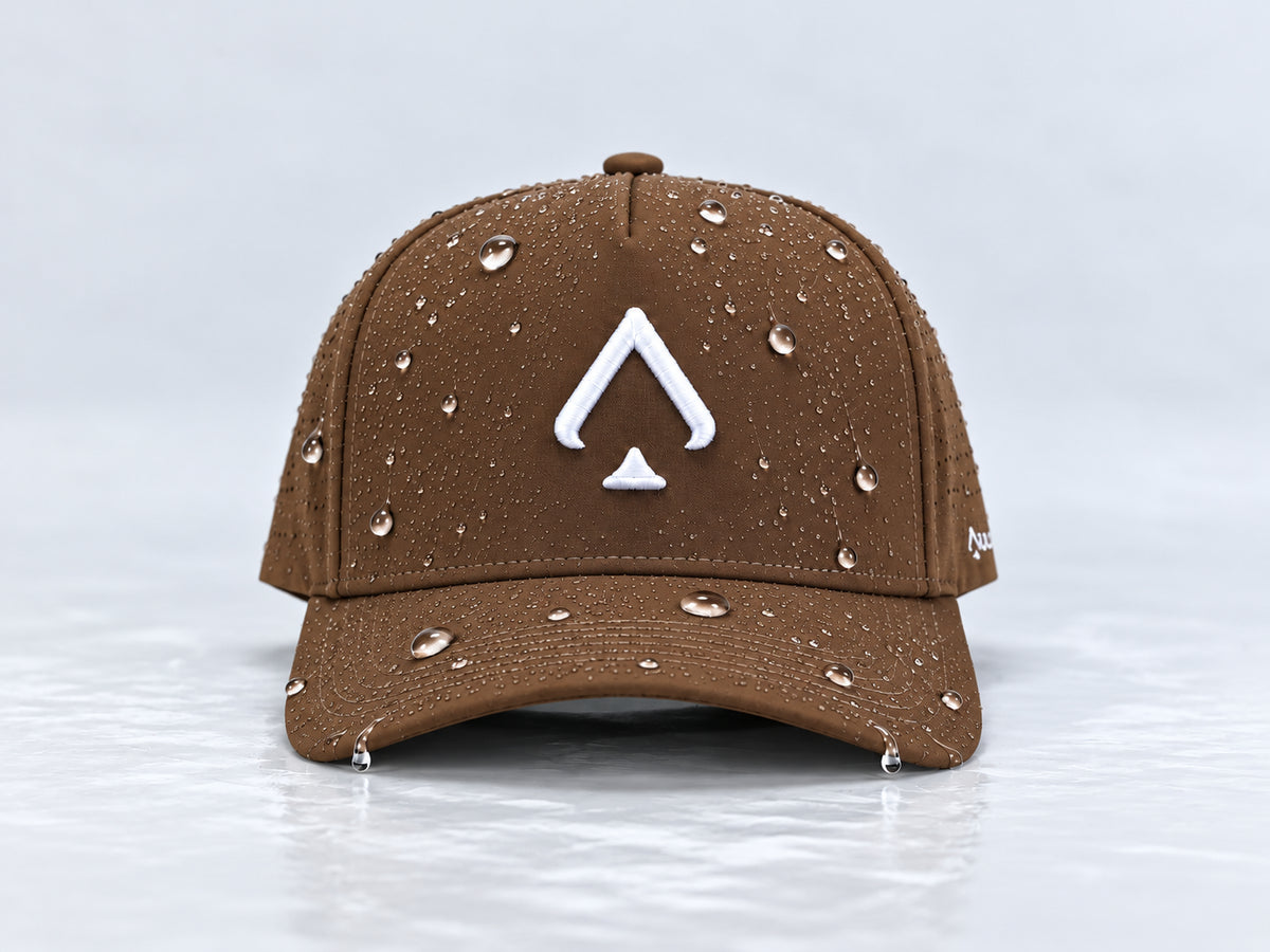 All In Lid Birdie Brown brown cap with white spade embroidery and beaded water droplets on the crown and brim, straight-on front view against a pale gray background.