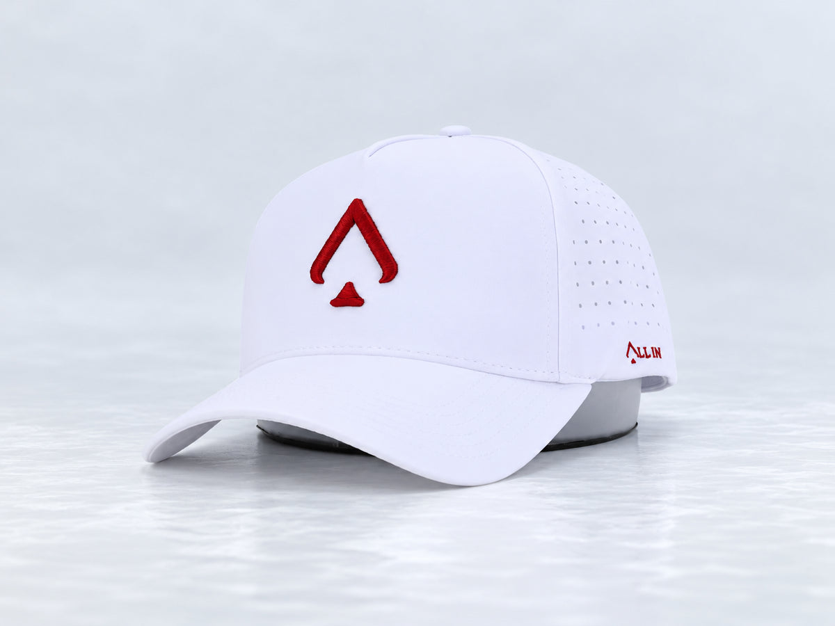 All In Lid Crimson Ice white cap with crimson red spade embroidery, front three-quarter view against a pale gray studio background.