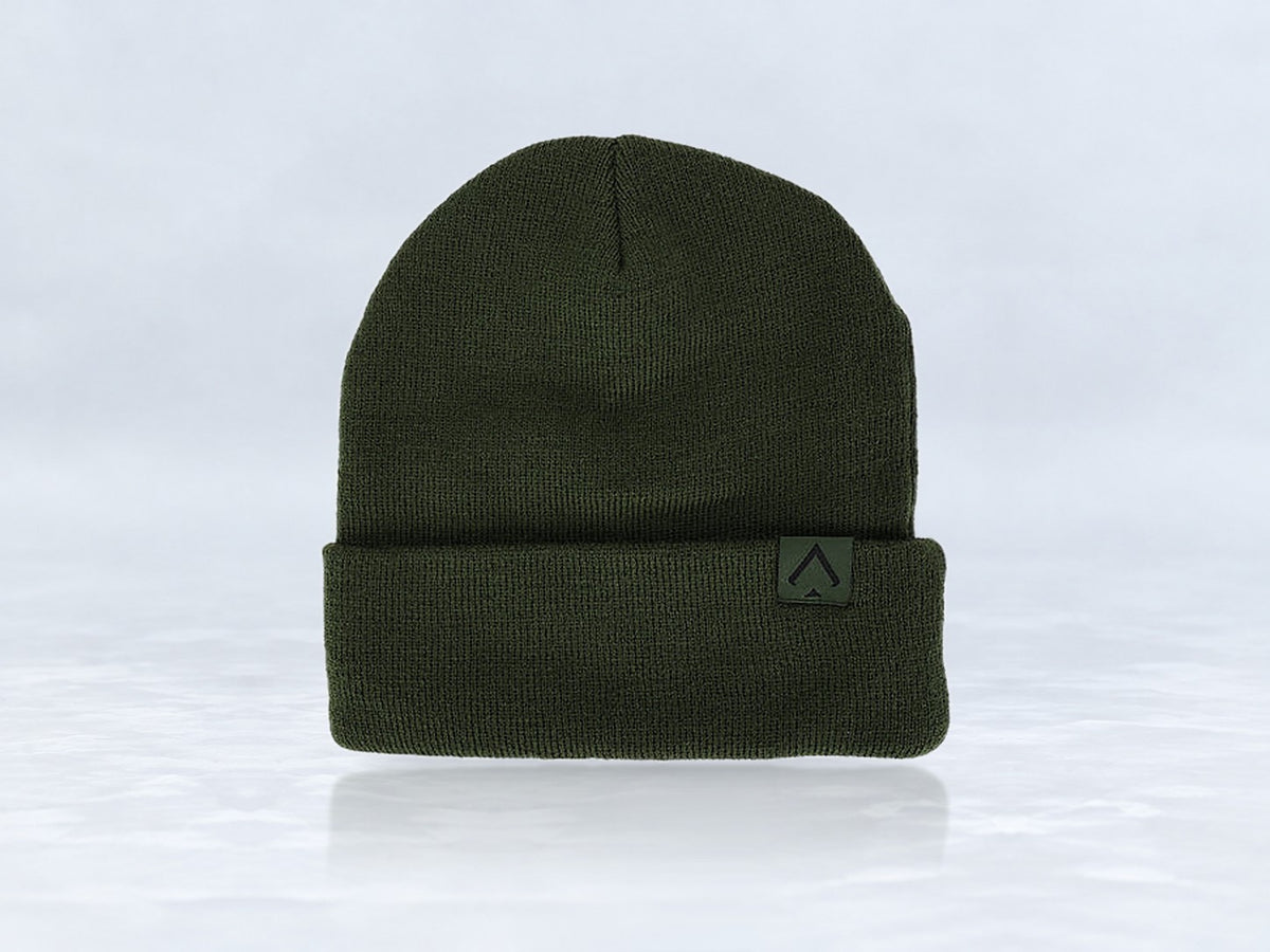 All In Lid Forest Green cuffed beanie in forest green knit with a tonal green logo patch, front view, against a pale gray studio background.