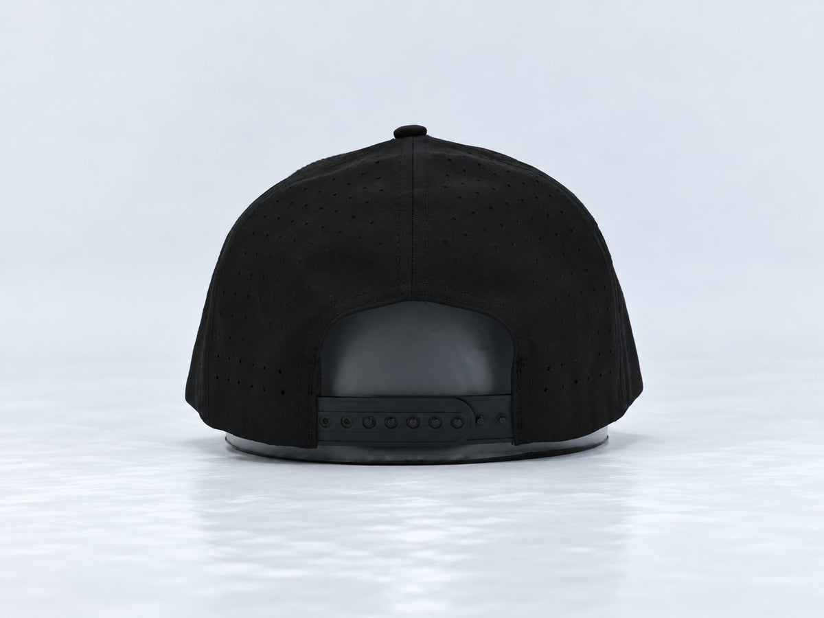 All In Lid Green Goblin black cap, rear view showing the adjustable snapback closure and perforated panels against a pale gray studio background.