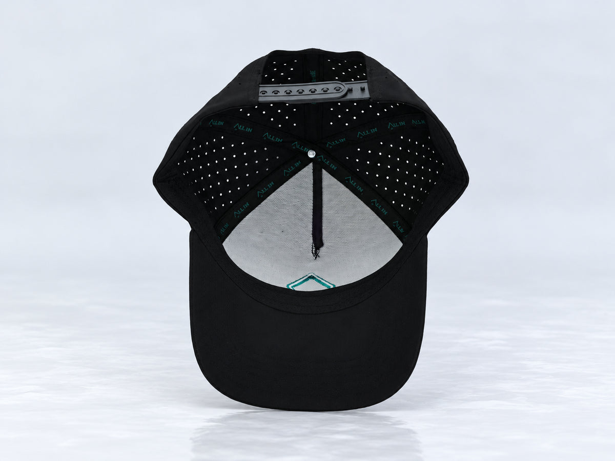 All In Lid Green Goblin black cap, interior view showing branded seam tape, the sweatband, mesh-backed front panel, and underside of the brim against a pale gray background.