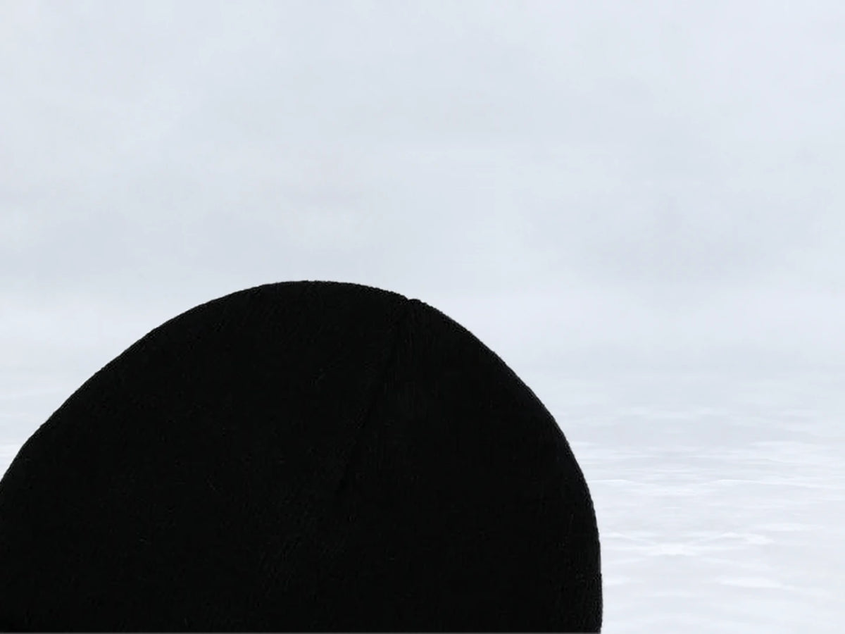 All In Lid Jet Black cuffed beanie in black knit, close-up of the knit crown, against a pale gray studio background.