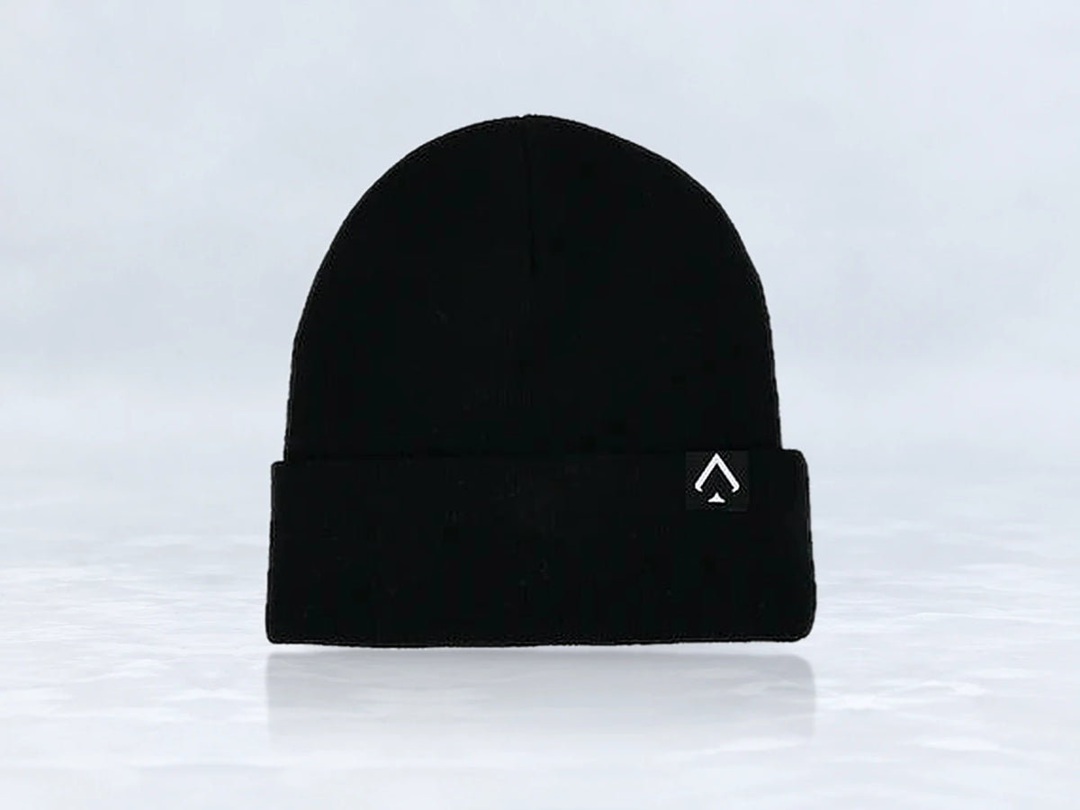 All In Lid Jet Black cuffed beanie in black knit with a white logo patch, front view, against a pale gray studio background.