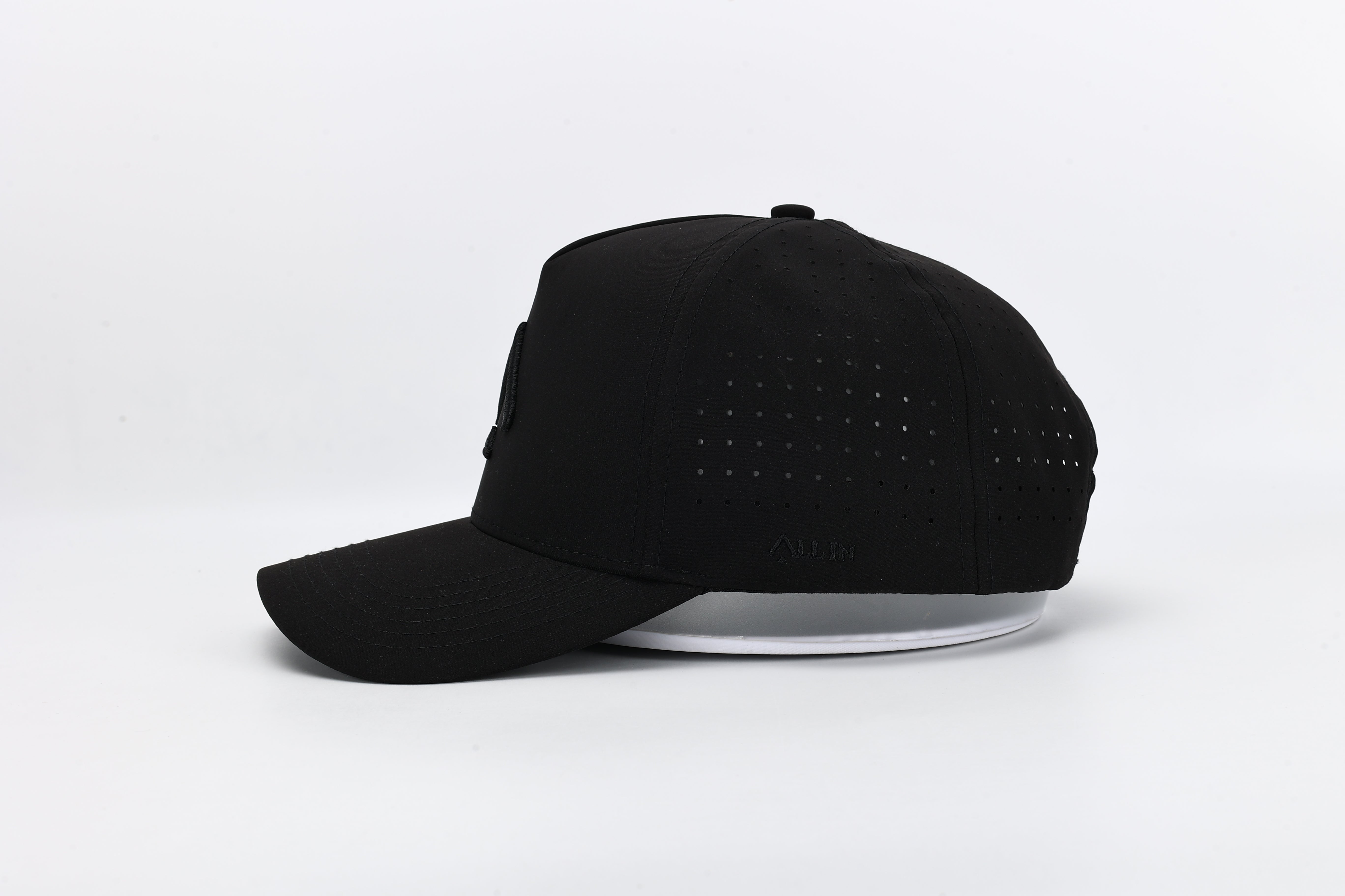 All In Wears Black Out cap in all-black performance fabric with a debossed, matching black spade logo and laser-cut ventilation.