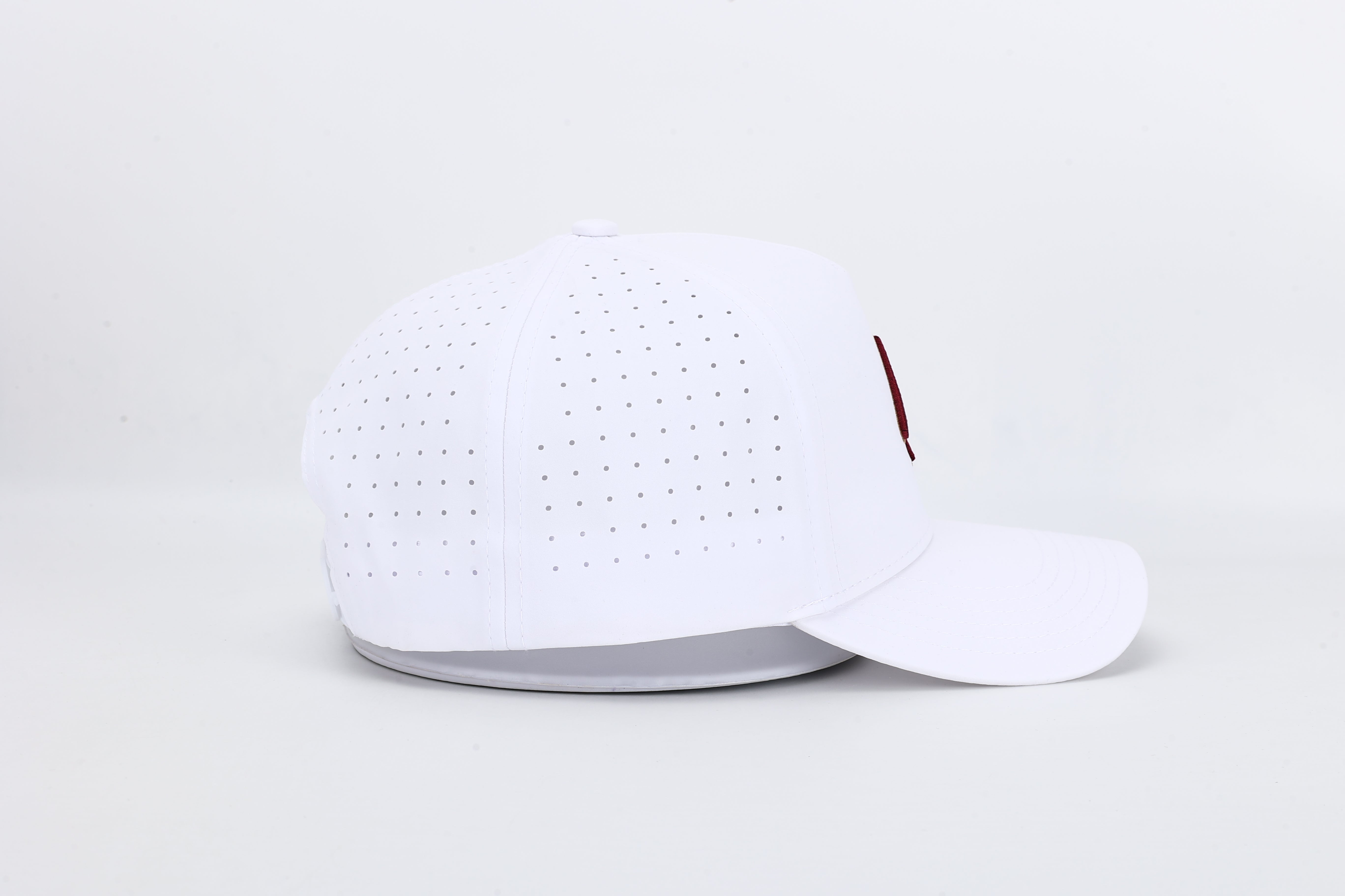 All In Wears Regal White performance cap, featuring a white body and an embroidered garnet and gold outline spade logo.