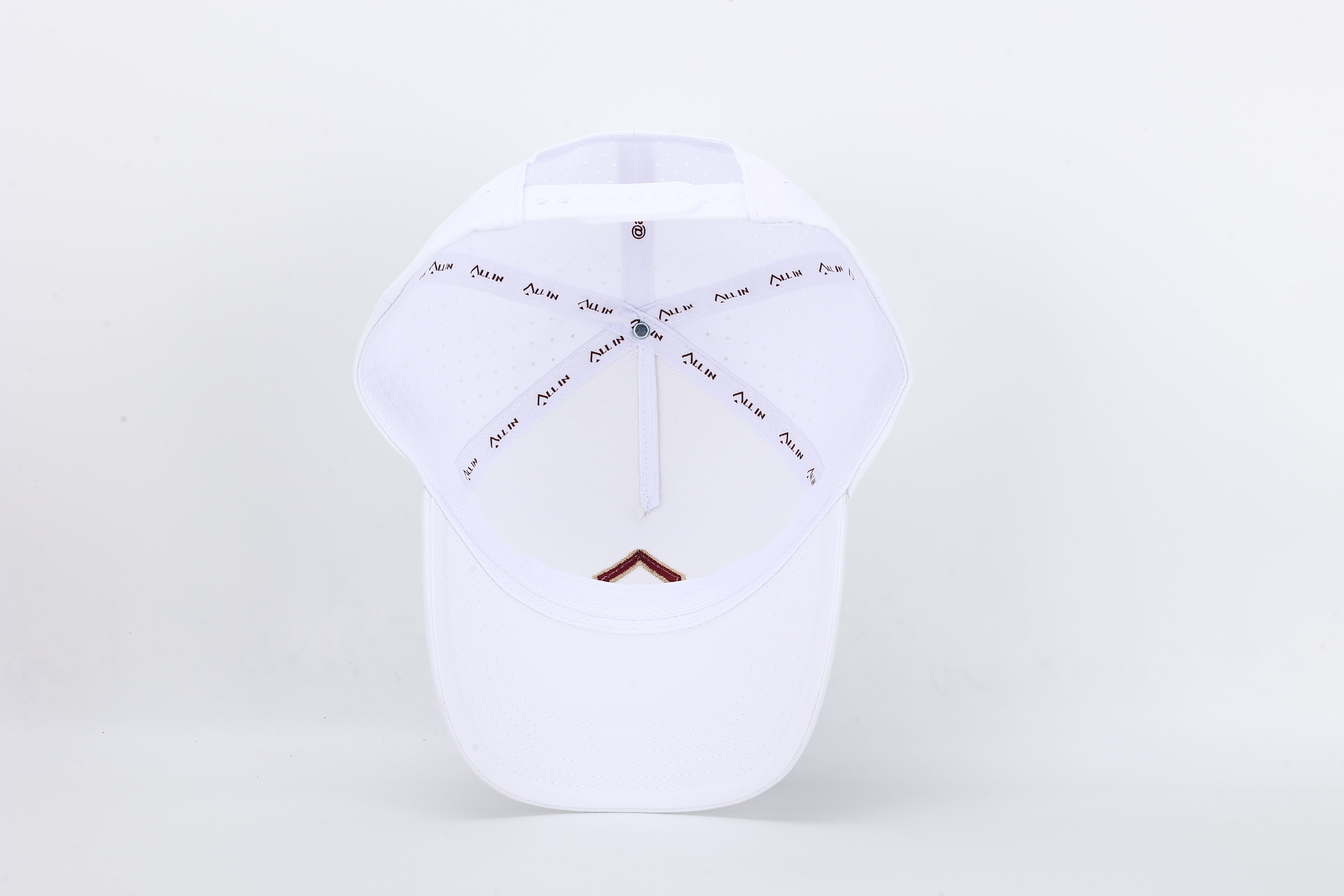 All In Wears Regal White performance cap, featuring a white body and an embroidered garnet and gold outline spade logo.