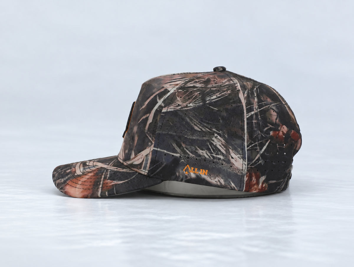 All In Lid Killa Camo hat, side profile, in woodland camouflage fabric with an orange-outlined black logo.