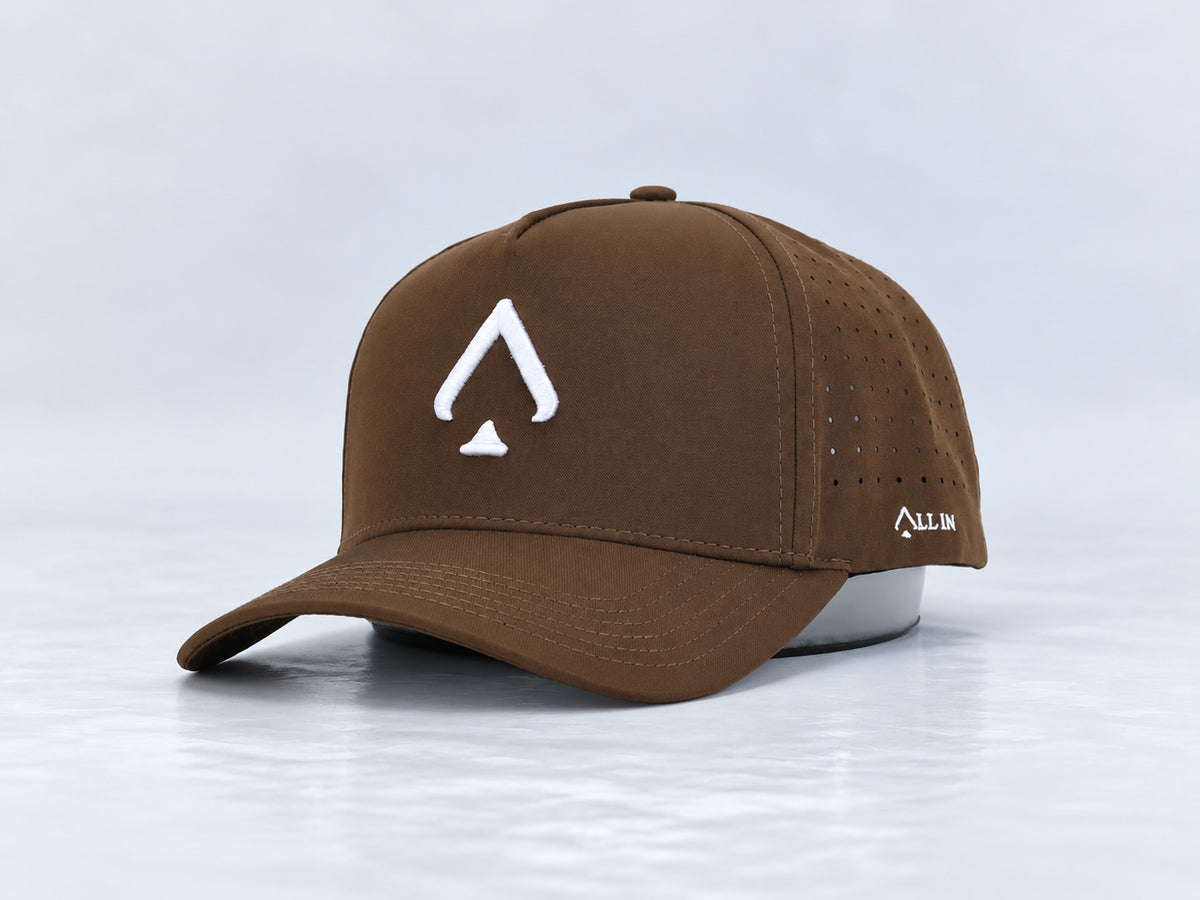 All In Lid Birdie Brown brown cap with white spade embroidery, front three-quarter view against a pale gray studio background.