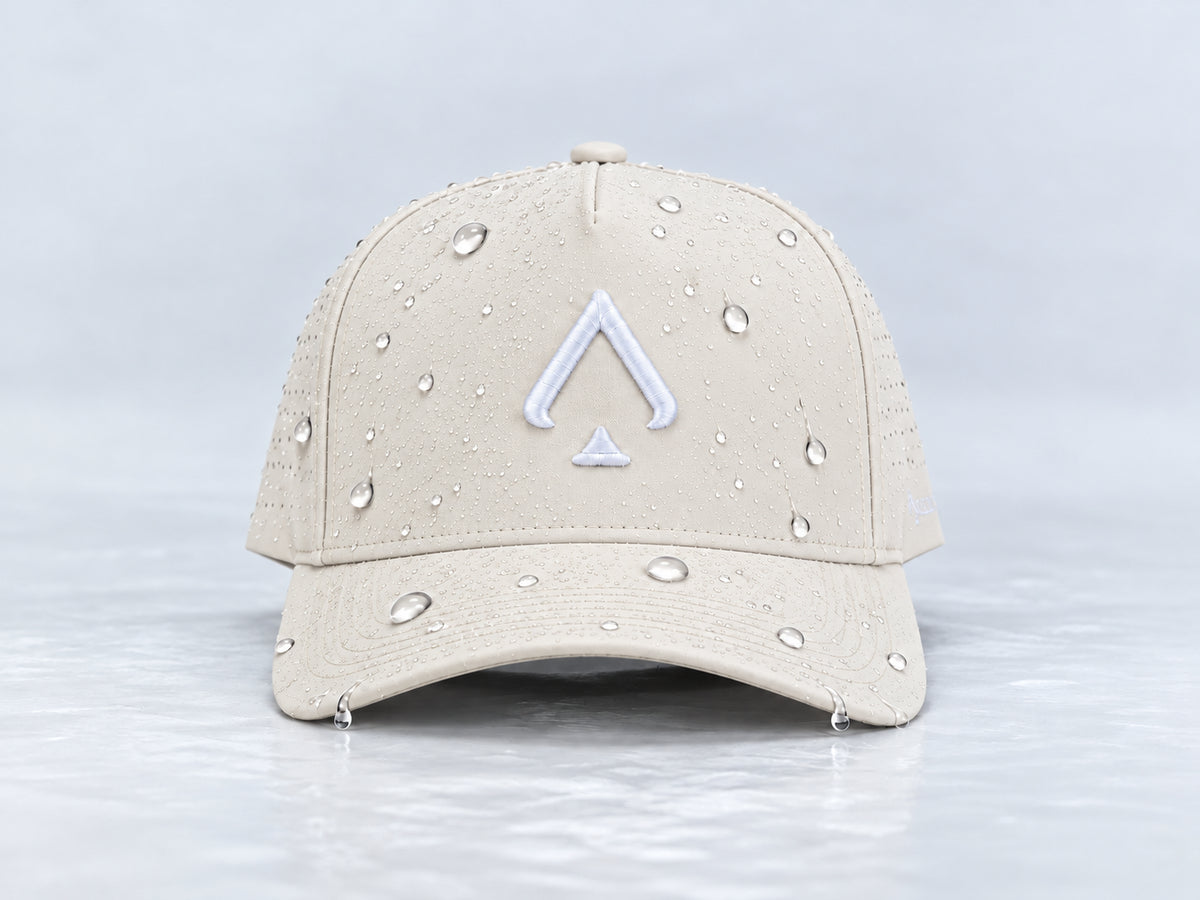 Front view of the All In Lid Butter hat with cream fabric and a white logo and water droplets on the crown and brim.