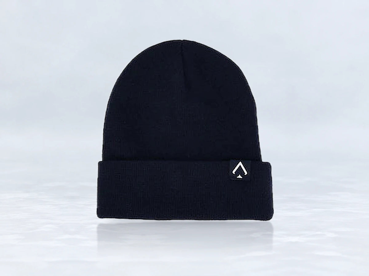 All In Lid Midnight Navy cuffed beanie in navy knit with a white logo patch, front view, against a pale gray studio background.