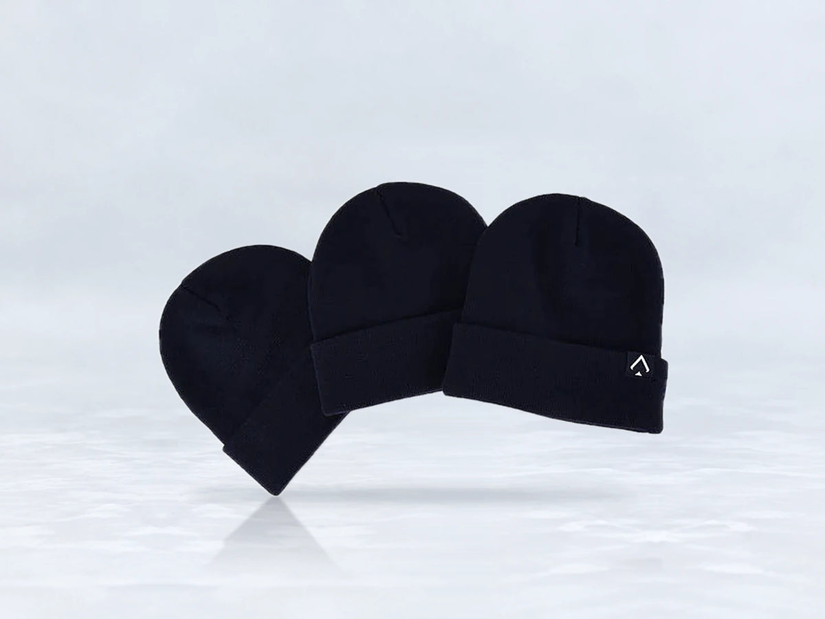 All In Lid Midnight Navy cuffed beanie in navy knit with a white logo patch, three beanies stacked, against a pale gray studio background.
